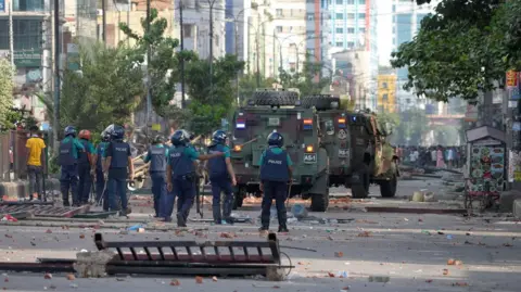 BBC Bangla Riot police at the scene of protests in Dhaka