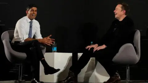 PA Media Former prime minister Rishi Sunak laughs with Elon Musk as both men talk at an event last year